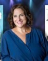 The author in the center smiling with short brown wavy hair wearing a blue blouse. Features covers of The Breakaway and The Griffin Sisters Greatest Hits both by Jennifer Weiner.