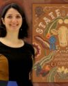 Brown embroidery background with author and Smithsonian Curator, Mary Savig, wearing a black dress with color blocks of brown and blue. She is smiling, with shoulder length dark hair. The book cover of State Fairs : Growing American Craft.
