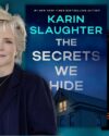 Author Karin Slaughter with short blonde hair, wearing a dark blue blazer and black shirt, a silver and blue pendant on a silver necklace. Book covers of The Secrets We Hide and We Are All Guilty Here by Karen Slaughter. Background is dark blue stormy sky.